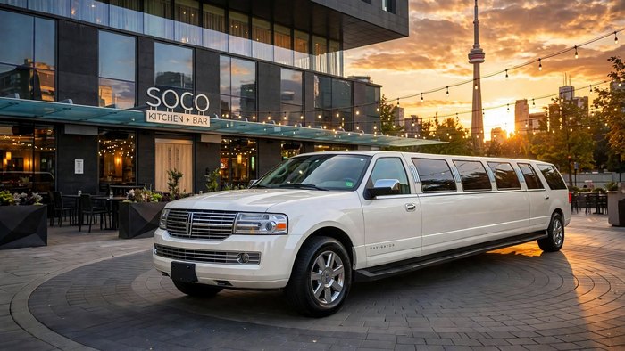 White Lincoln Navigator stretch limousine outside a restaurant with the CN Tower in the sunset sky