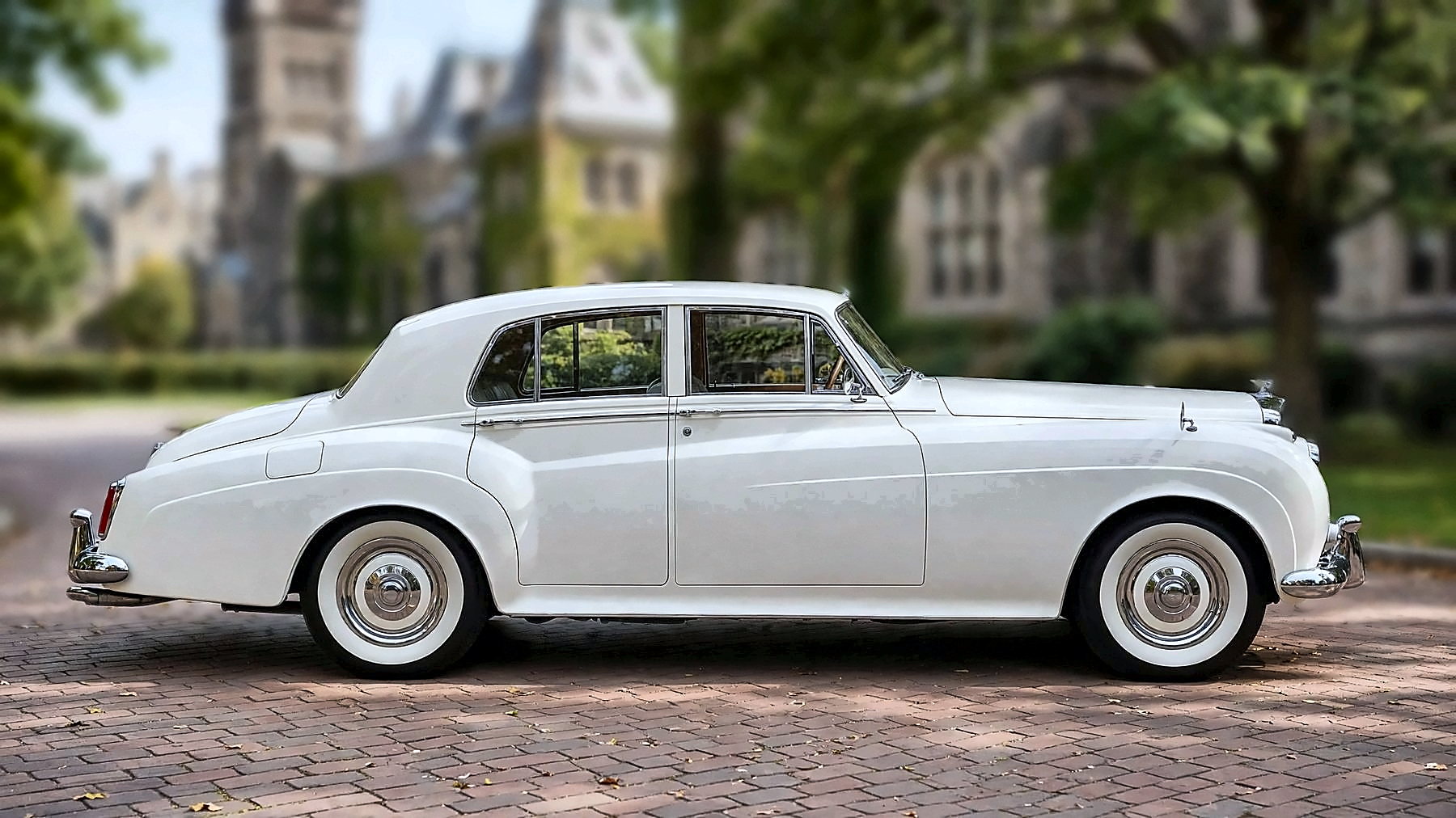 The white 1959 Bentley S in side profile on a university campus