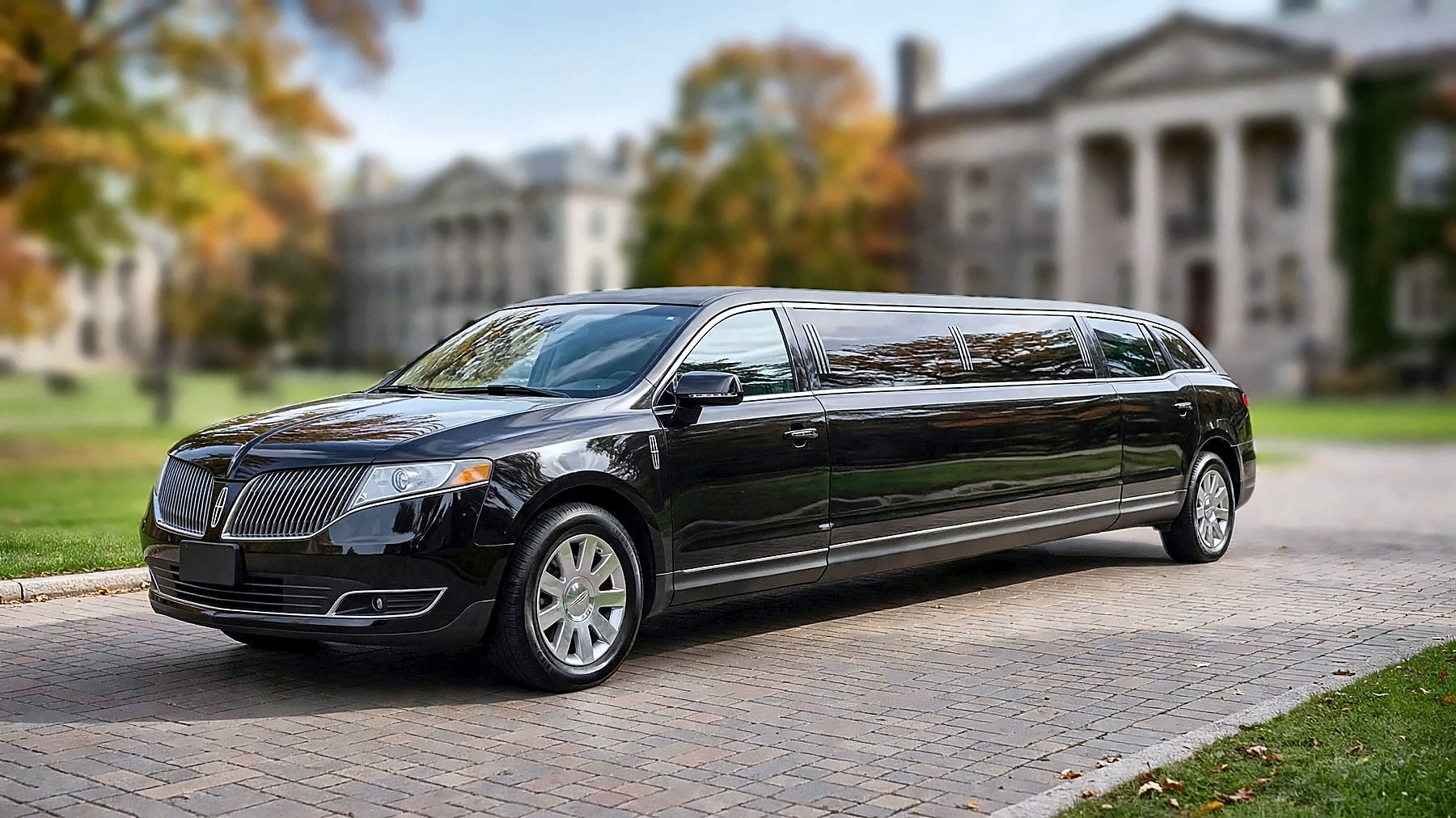 The black Lincoln MKT Stretch on a university campus in autumn