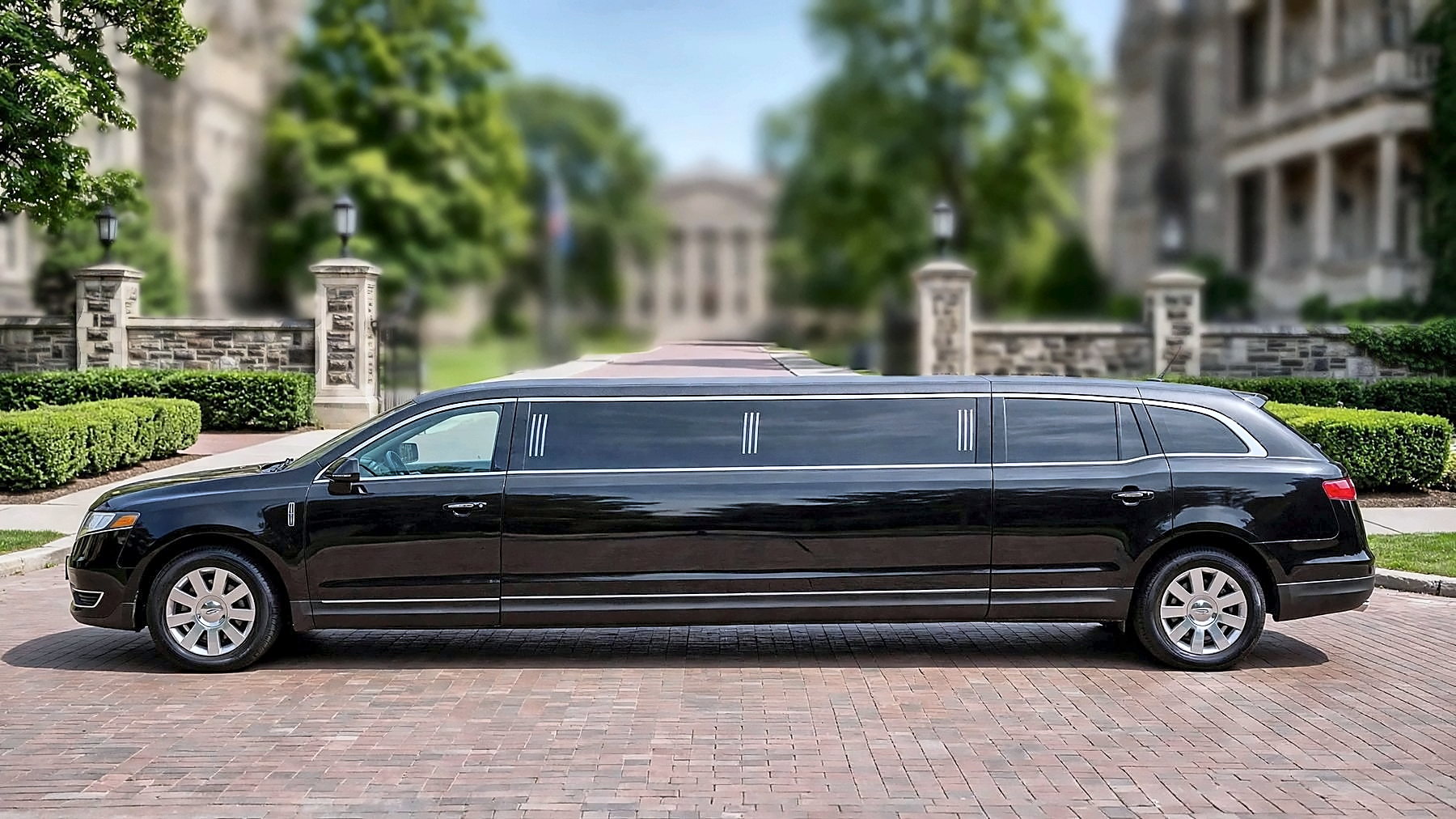 The black Lincoln MKT Stretch in side profile on a university campus