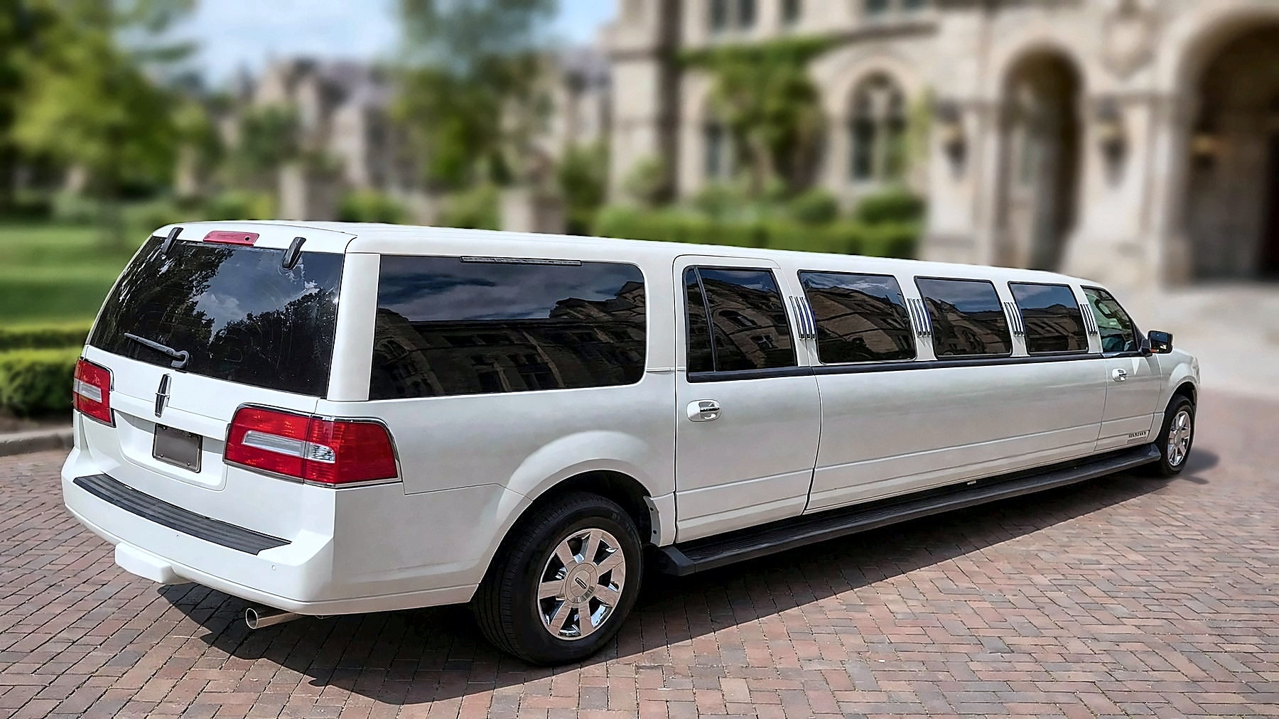 The white Lincoln Navigator Stretch from the rear on a university campus
