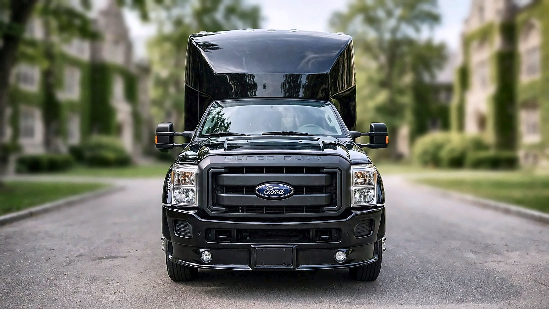 The black Ford F-550 Party Bus from the front on a university campus