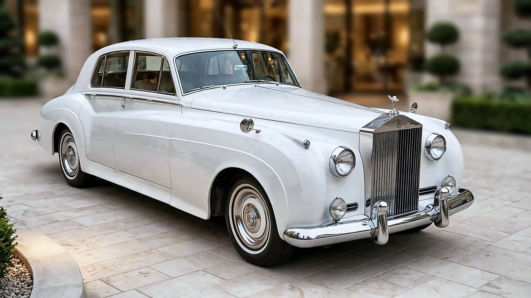 The white 1959 Rolls-Royce at an estate entrance