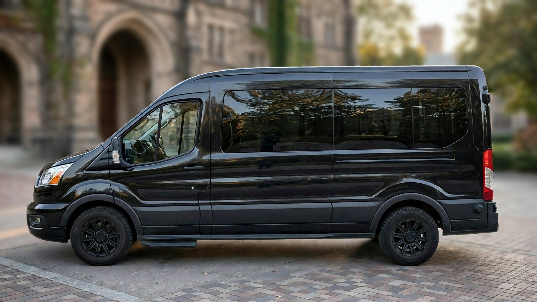 The black Ford Transit 250 from the side on a university campus